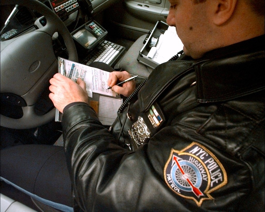 A police officer writes a speeding ticket after cl